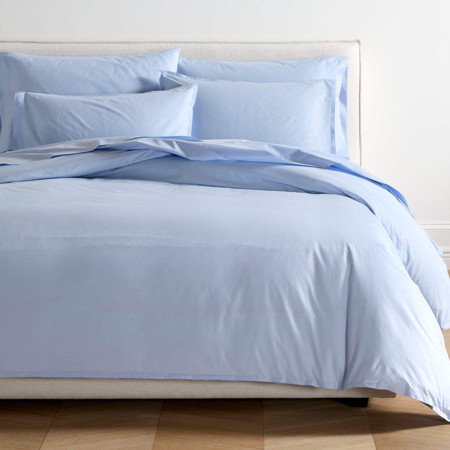 Oxford Blue Italian Percale Duvet Set with two shams on a bed.