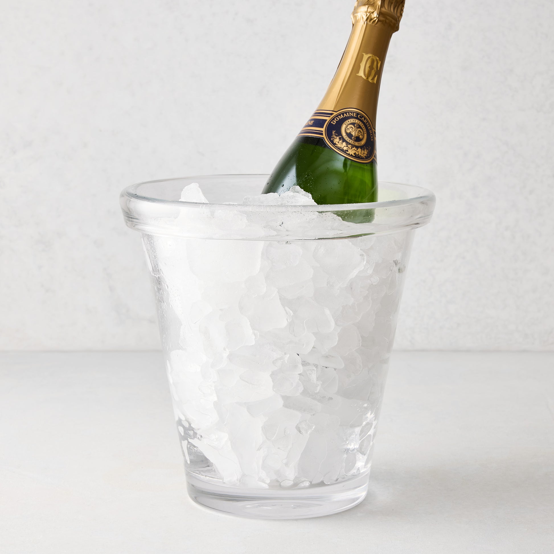 Clear Oxford Glass Ice Bucket with hand-molded rim, filled with ice and a green champagne bottle.