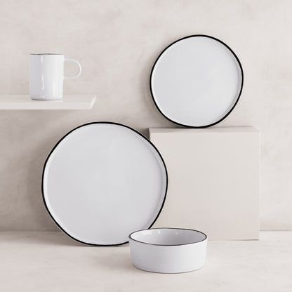 White stoneware mug, dinner plate, salad plate, and bowl with black rims from the Pacific collection.