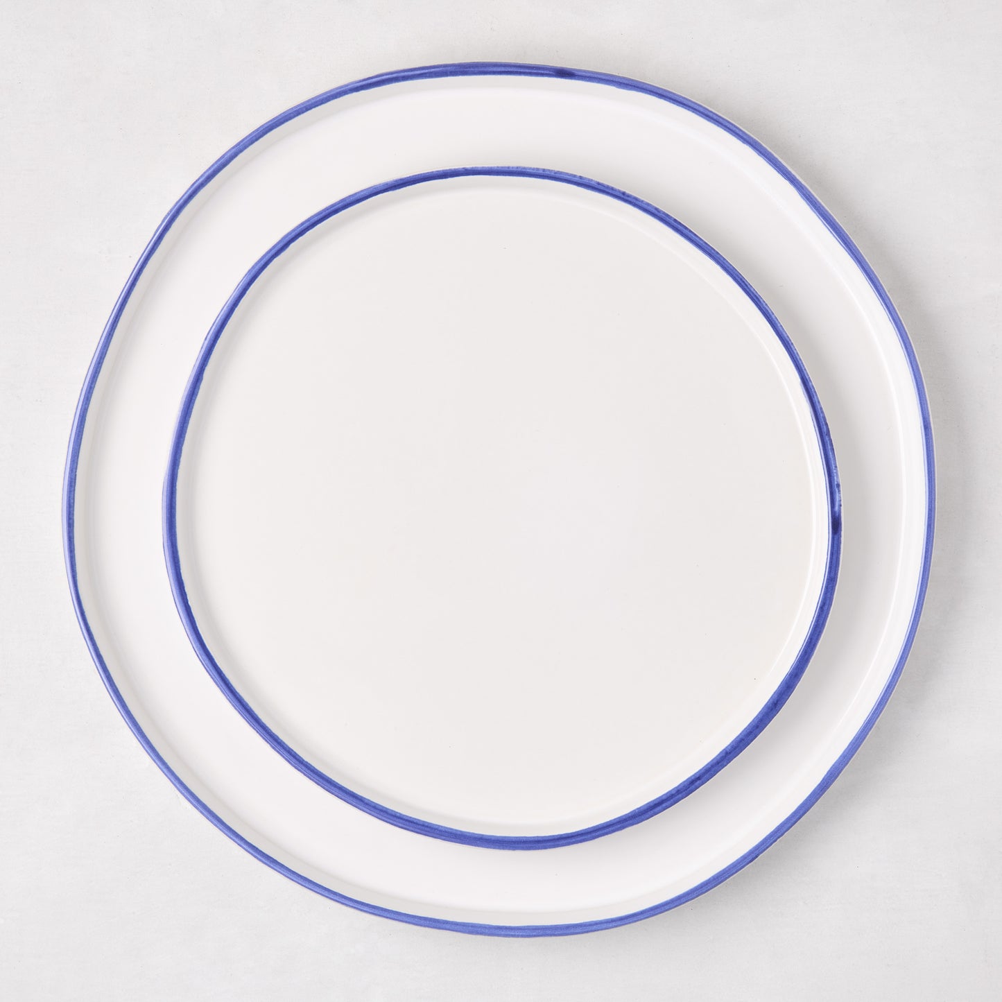 Pacific Blue-Rimmed Stoneware Dinner Plate, 11" diameter, with hand-painted blue edge and irregular shape.