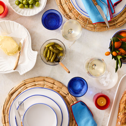 Pacific Blue-Rimmed Stoneware Salad Plate with hand-painted blue edge, 8" diameter, on a woven placemat.