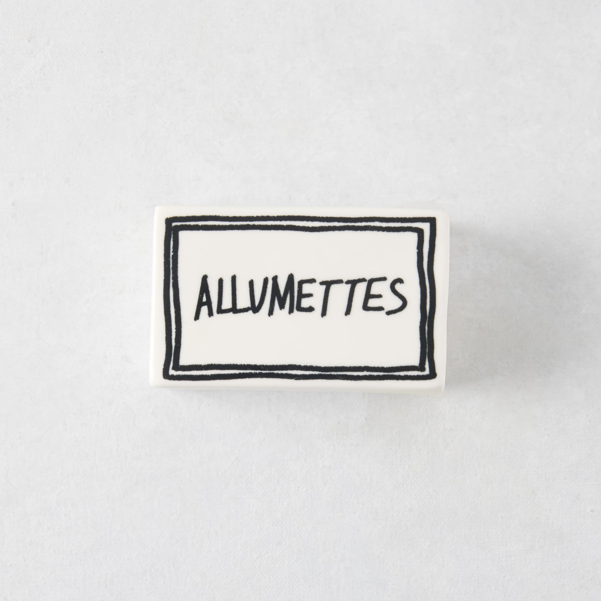 Rectangular white porcelain match box with hand-painted black border and Allumettes text, 3.54 x 2.17 inches.