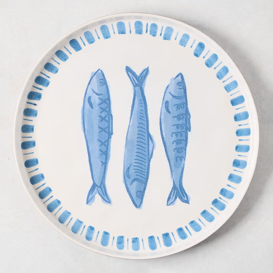 White terracotta round serving platter with three hand-painted blue sardines and a blue border.