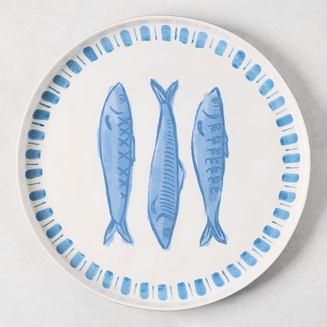 White terracotta round serving platter with three hand-painted blue sardines and a blue border.