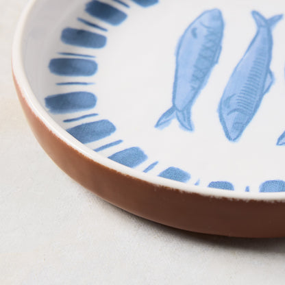 White terracotta salad plate with blue hand-painted sardine and stripe design.