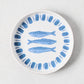 White terracotta salad plate with hand-painted blue sardines and a blue striped rim.