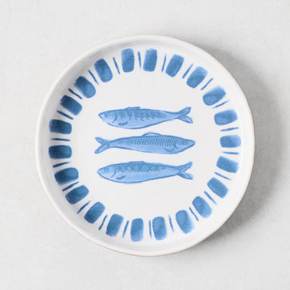 White terracotta salad plate with hand-painted blue sardines and a blue striped rim.