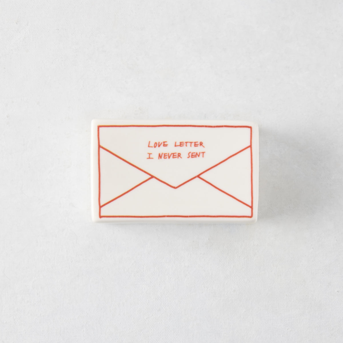 Rectangular white ceramic match box featuring a red hand-drawn envelope design with the text Love Letter I Never Sent.