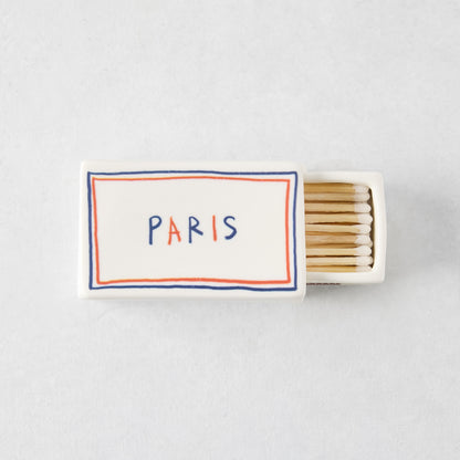 White porcelain match box with red and blue border, Paris text, and wooden matches, 3.54 x 2.17 inches.
