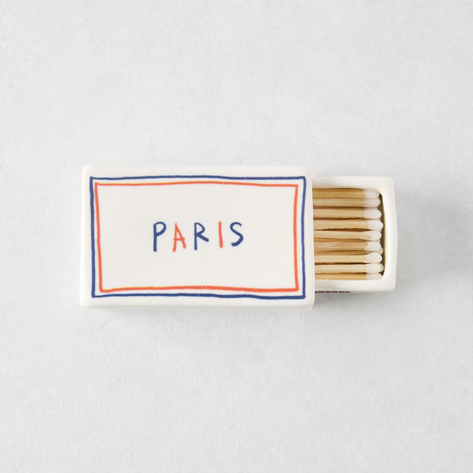 White porcelain match box with red and blue border, Paris text, and wooden matches, 3.54 x 2.17 inches.