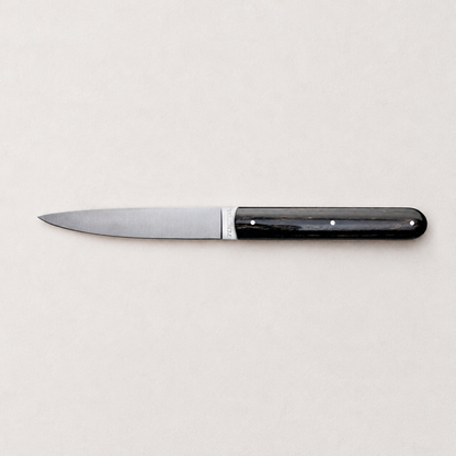 Perceval 9.47 stainless steel knife with a dark polished pakkawood handle on a neutral background.