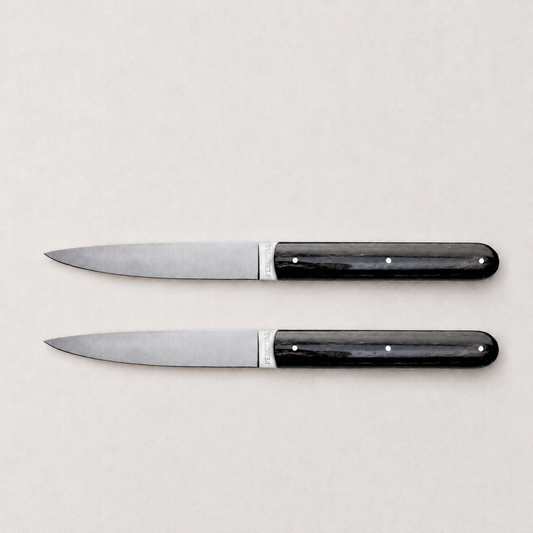 Set of two Perceval 9.47 steak knives with stainless steel blades and dark, polished pakkawood handles.