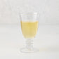 Palermo Stemmed Wine Glass, clear hand-blown glass with a curved lip and artistic ribbed stem, filled with white wine.