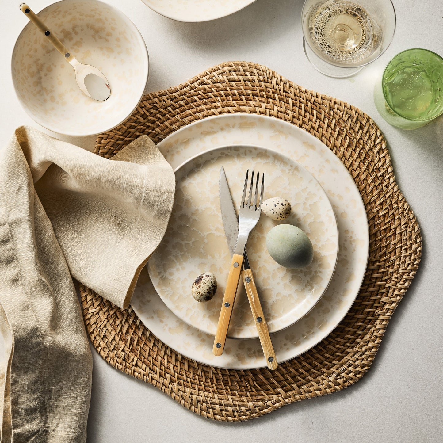 Paris Bistro 5-piece flatware set with stainless steel heads and cream-colored acrylic handles on a woven placemat.