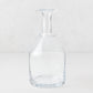 Clear mouth-blown crystalline glass wine carafe with a broad base, ridged neck, and rippled rim, 10 inches tall.