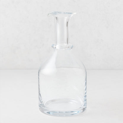 Clear mouth-blown crystalline glass wine carafe with a broad base, ridged neck, and rippled rim, 10 inches tall.