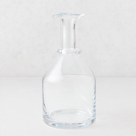 Clear mouth-blown crystalline glass wine carafe with a broad base, ridged neck, and rippled rim, 10 inches tall.