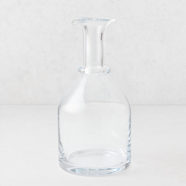 Clear mouth-blown crystalline glass wine carafe with a broad base, ridged neck, and rippled rim, 10 inches tall.