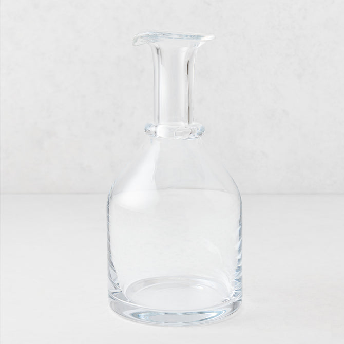 Clear mouth-blown crystalline glass wine carafe with a broad base, ridged neck, and rippled rim, 10 inches tall.