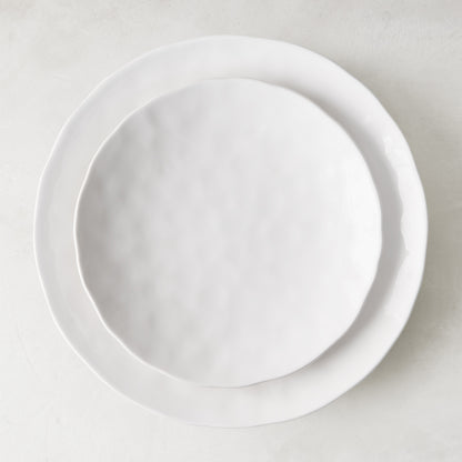 Pebble White 11" ceramic dinner plate with subtle textures, stacked on a larger white plate.