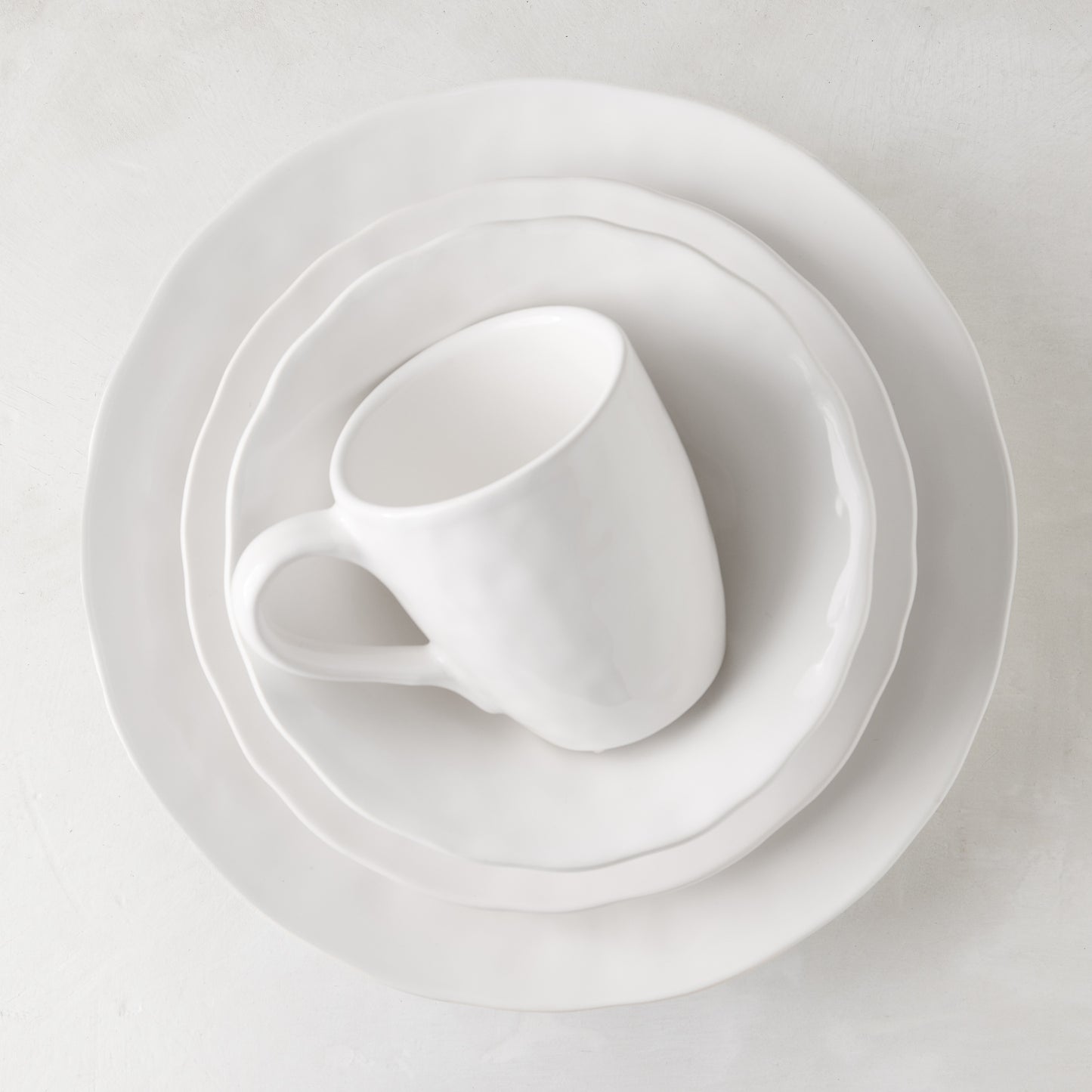 Pebble White ceramic mug and two plates, subtly textured, creamy white glaze.