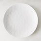 Pebble White 11" ceramic dinner plate with subtle textured surface and creamy white glaze.