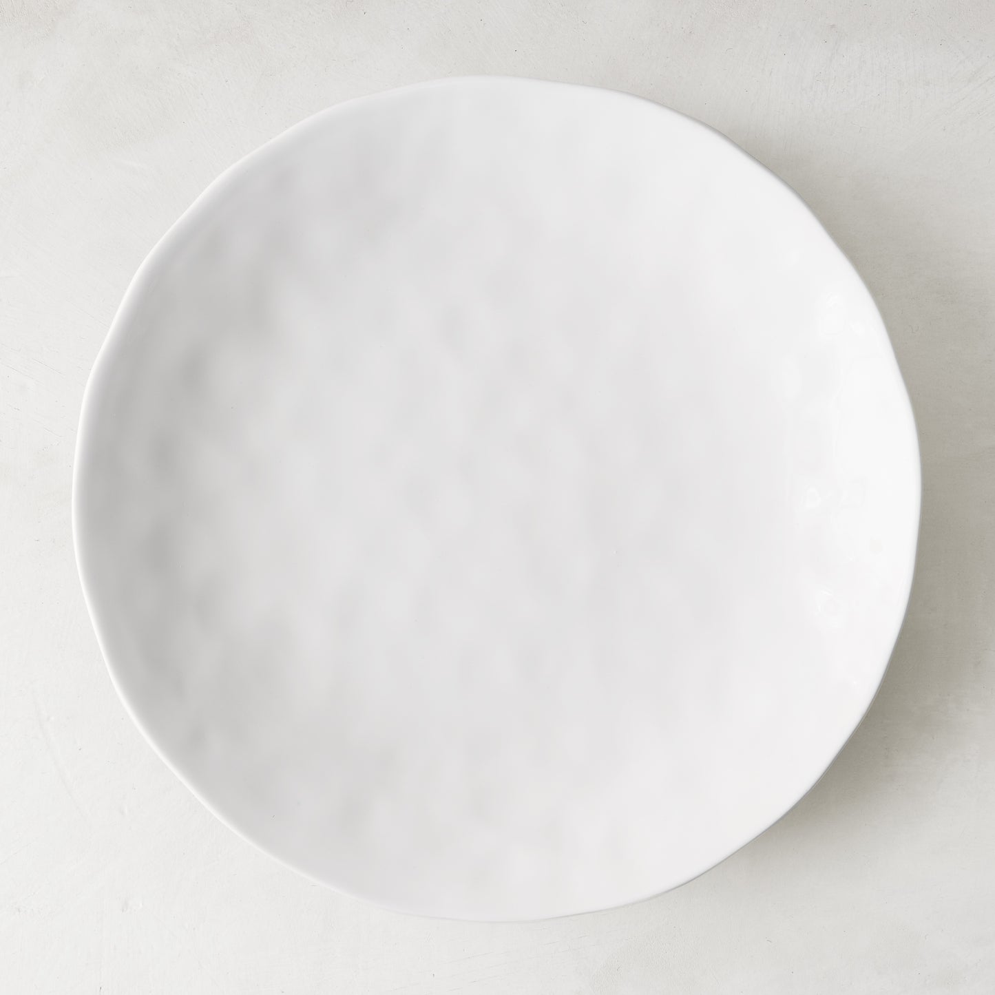 Pebble White 11" ceramic dinner plate with subtle textured surface and creamy white glaze.