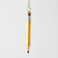 Hand-painted glass pencil ornament with yellow body, silver glitter accents, and a gold hanging loop.