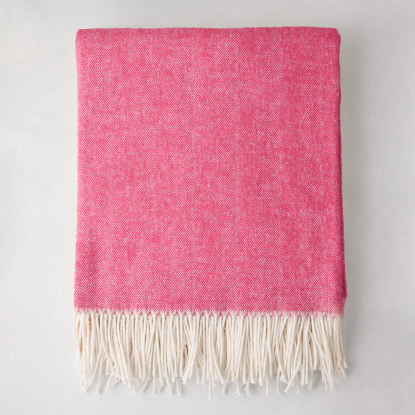 Peony Pink Italian Herringbone Throw Blanket, cashmere-soft cotton-acrylic blend, with white fringe.