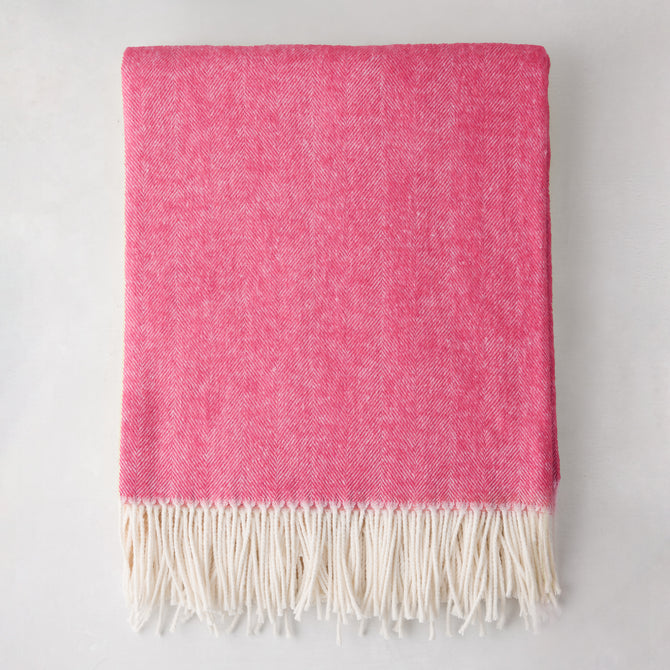 Peony Pink Italian Herringbone Throw Blanket, cashmere-soft cotton-acrylic blend, with white fringe.