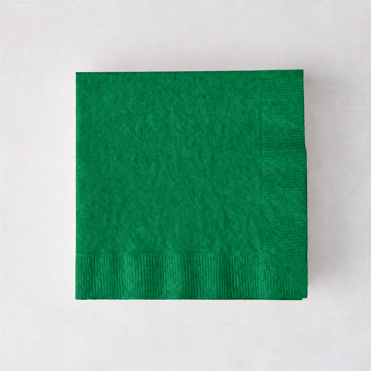 Square 5.5-inch green 3-ply paper cocktail napkin with a textured border on a light background.