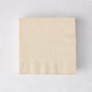 Square ivory 3-ply paper cocktail napkin with a textured border on a light background.