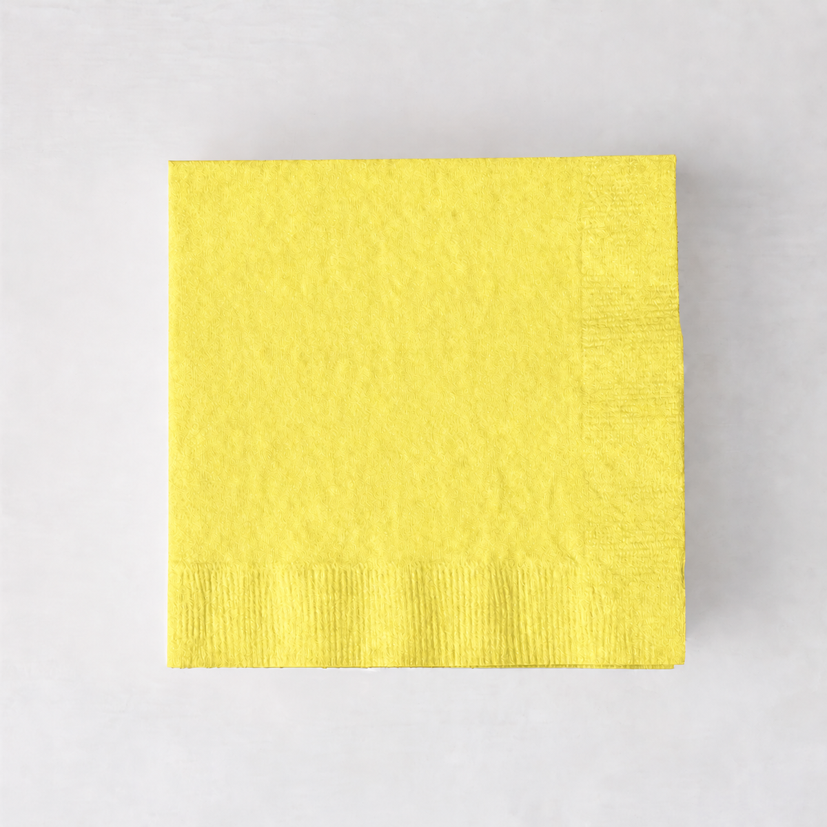 Square pale yellow 3-ply paper cocktail napkin with a textured border.