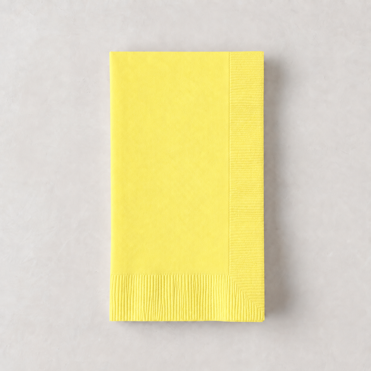 Pale yellow 3-ply disposable paper hand towel with a textured border, 8 by 4.5 inches.