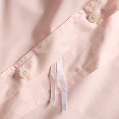 Close-up of Petal Pink Italian Percale Duvet Set with button closures and white ties.
