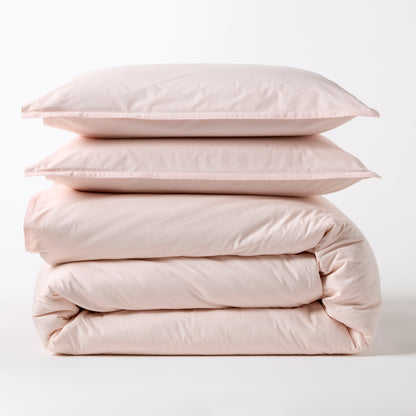 Stacked Petal Pink Italian Percale Duvet Set with two shams and a folded duvet cover.