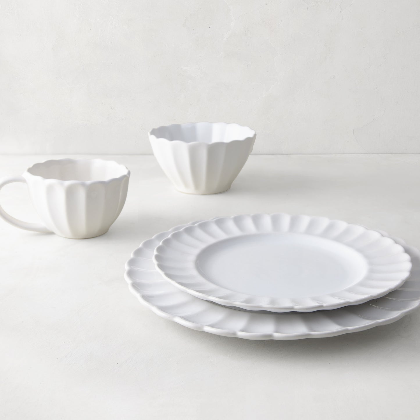 White Petal Stoneware Dinner Plate, salad plate, bowl, and mug with scalloped edges.