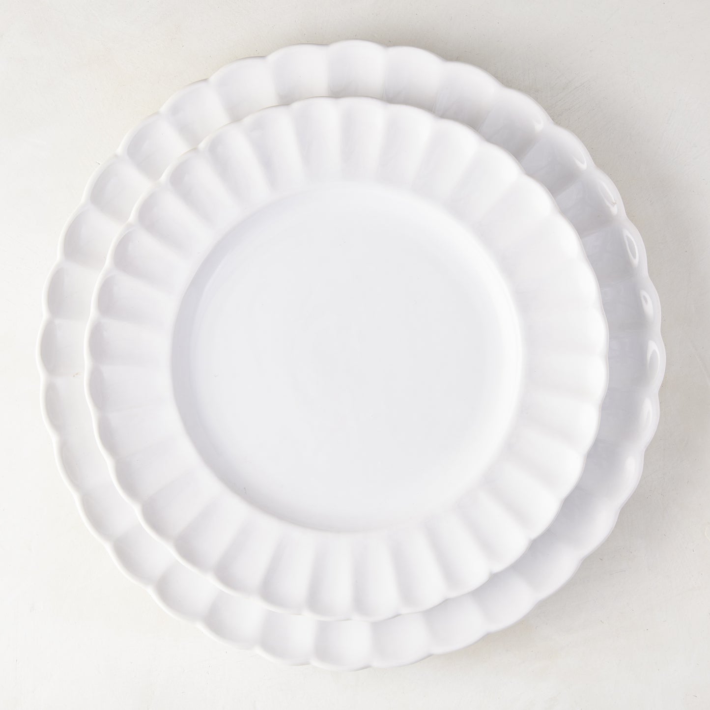 Two white Petal Stoneware Dinner Plates, 11.25" diameter, with scalloped edges, stacked on a white surface.