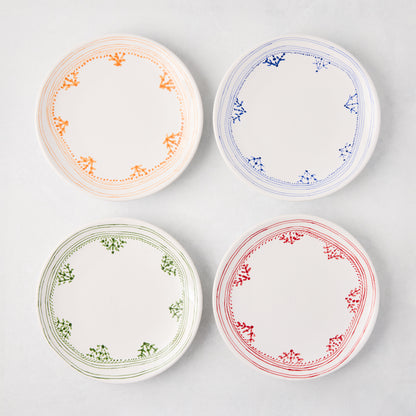 Four Peter Dunham + Hudson Grace Blue Fez appetizer plates with hand-painted borders in orange, blue, green, and red.