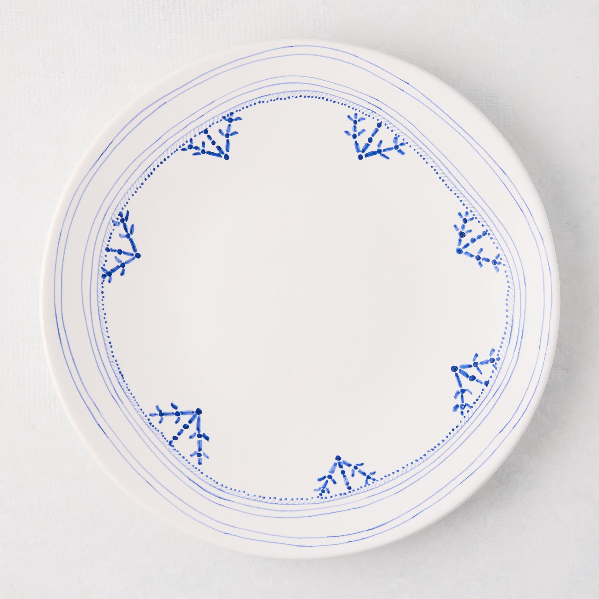 Peter Dunham + Hudson Grace Blue Fez dinner plate, white with hand-painted blue border pattern.