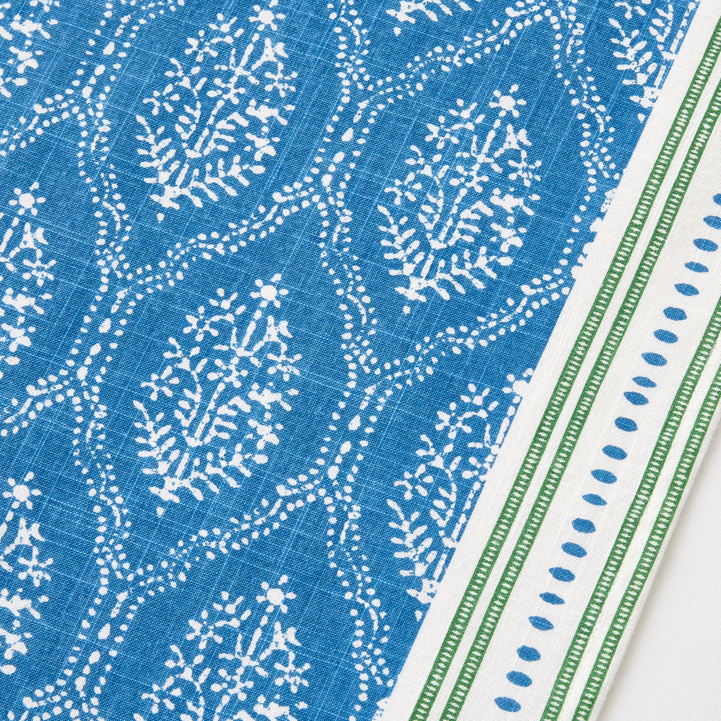 Blue Jaali floral print cotton slub table runner with a green and white striped border.