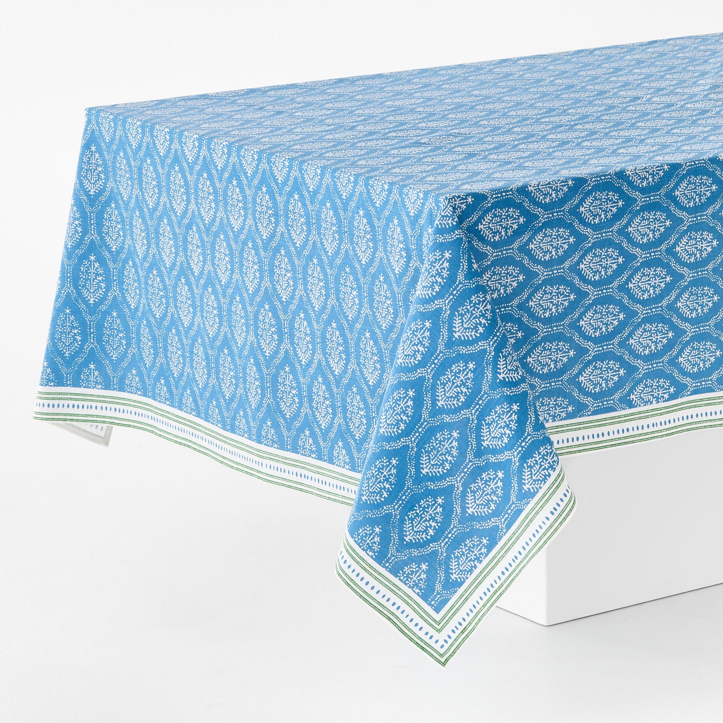 Peter Dunham blue and white cotton slub rectangular tablecloth with a floral Jaali print and green border.