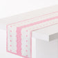 Peter Dunham + Hudson Grace bright pink Fez print cotton slub table runner on a white table.