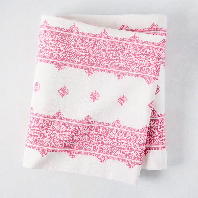 Folded Peter Dunham + Hudson Grace Bright Pink Fez Stripe cotton slub tablecloth with intricate pattern.