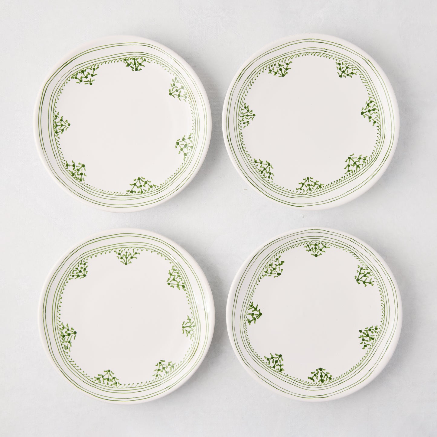Four Peter Dunham + Hudson Grace Green Fez appetizer plates with hand-painted green borders.