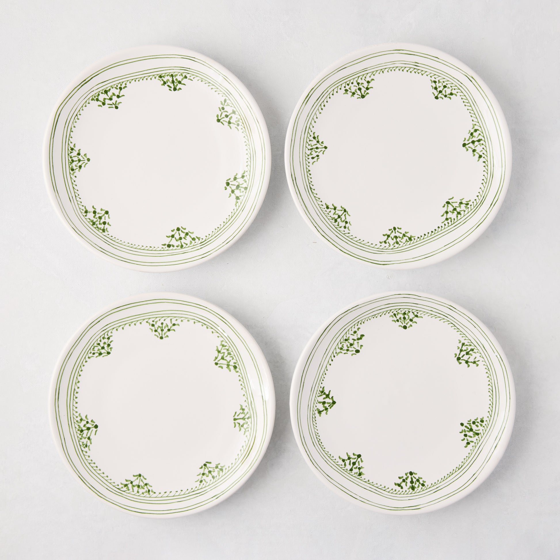 Four Peter Dunham + Hudson Grace Green Fez appetizer plates with hand-painted green borders.