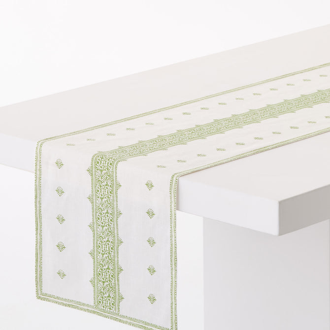 Peter Dunham + Hudson Grace green Fez stripe 108-inch cotton slub table runner on a white table.