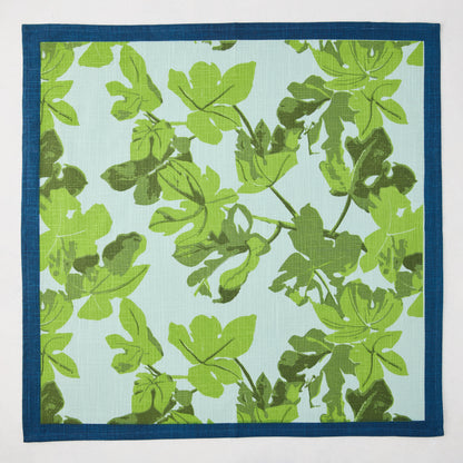 Peter Dunham + Hudson Grace green fig leaf printed blue cotton slub napkin with a dark blue border.