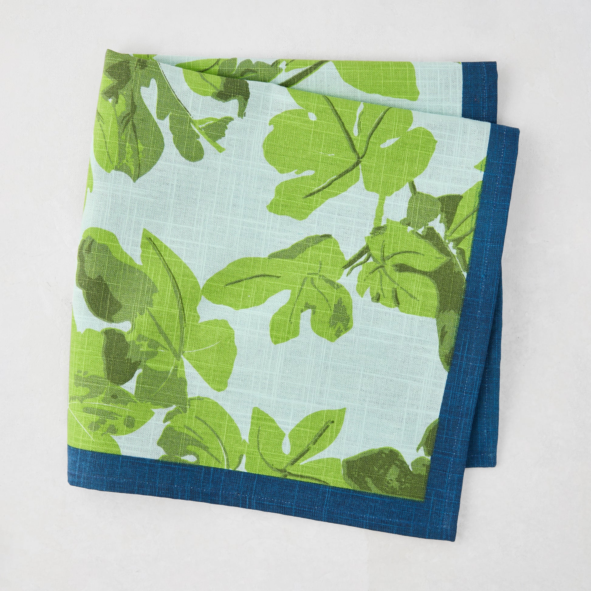 Peter Dunham + Hudson Grace Green Fig Leaf Printed Blue Napkin with blue border, 100% cotton slub.