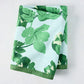 Peter Dunham + Hudson Grace Green Fig Leaf Printed Pale Blue Tablecloth, 100% cotton slub, folded.